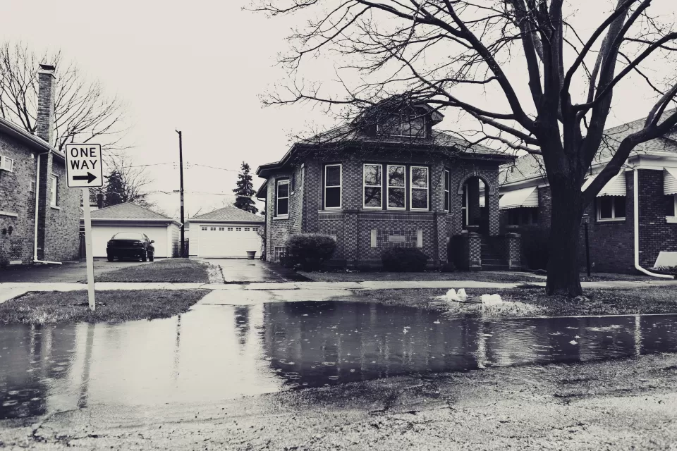 Sepia-toned photo of flooded street with residential home